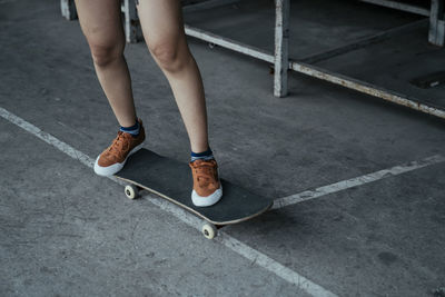 Low section of woman standing on skateboard