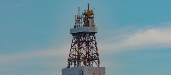 Low angle view of communications tower against sky