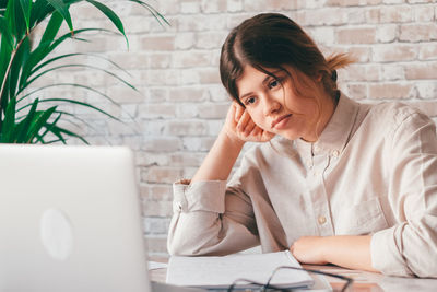 Teenage girl using laptop at table