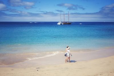 Rear view of woman walking on beach