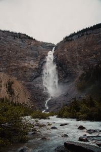 Scenic view of waterfall against sky