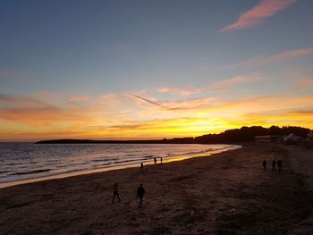 Silhouette of people at beach during sunset