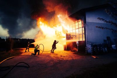 Firefighters spraying water on fire in building