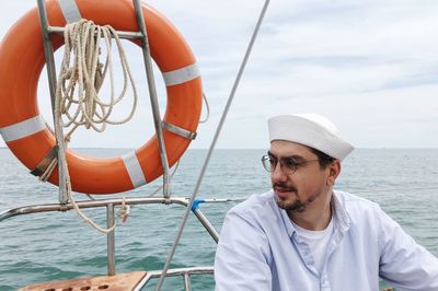 Portrait of man sailing in sea against sky