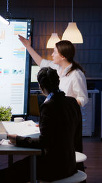 Rear view of woman working at table