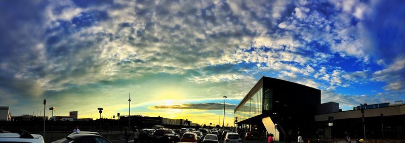 City street against cloudy sky at sunset