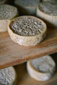 Close-up of cheese on wooden shelves