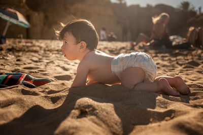 Boy playing on sand at beach