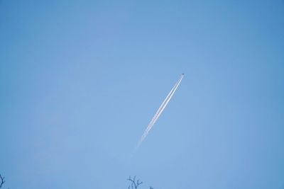 Low angle view of vapor trail against clear blue sky