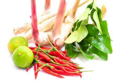 Close-up of red chili peppers over white background