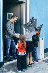 Halloween autumn holiday. a group of children in costumes go from door to door and collect sweets. 