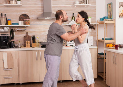 Full length of couple standing at home