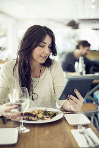 Woman using digital tablet in restaurant