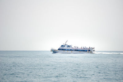 Ship sailing on sea against clear sky