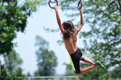 Rear view of woman with arms raised