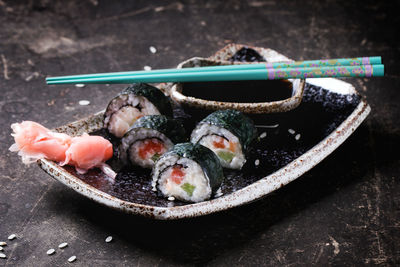 Close-up of sushi rolls with salmon in plate on table