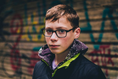 Portrait of young man in urban setting with graffiti