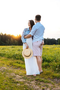 Rear view of couple kissing on land