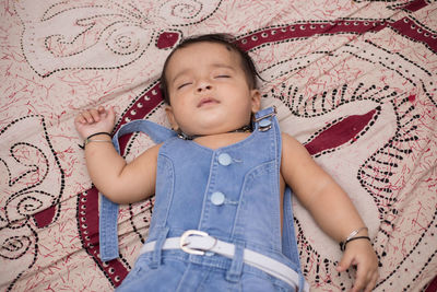 High angle view of baby lying on bed