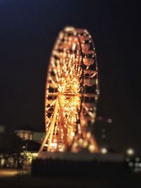 Illuminated ferris wheel at night