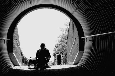 Woman with dogs crouching in tunnel