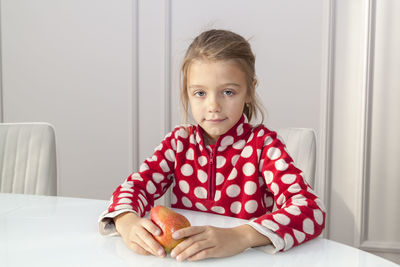 Portrait of a girl sitting on table