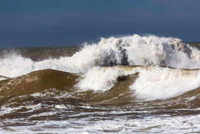 Sea waves splashing against blue sky