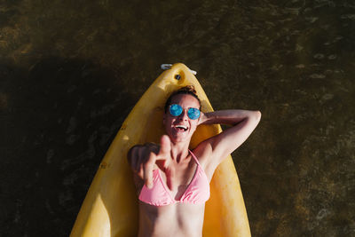 High angle view of woman lying down on canoe