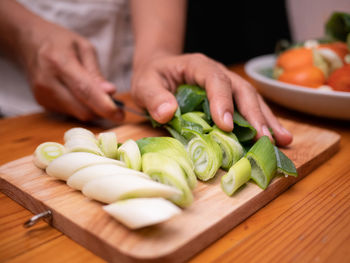 Midsection of man preparing food on cutting board