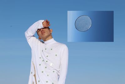 Low angle view of man against blue sky