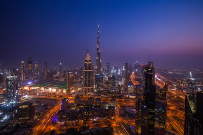 Illuminated city against sky at night