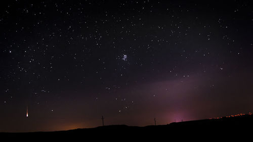 Meteor and star field over landscape at night