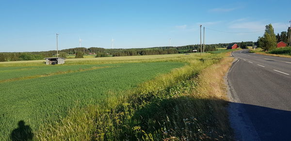 Road amidst field against sky