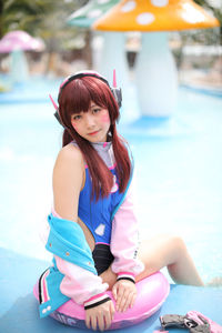 Portrait of woman with red hair sitting by swimming pool