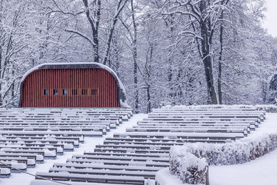 Snow covered bench against building