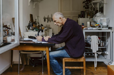 Upset senior man at table in living room