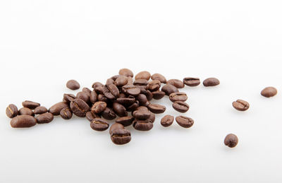 High angle view of coffee beans against white background