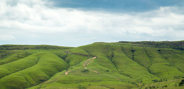 Scenic view of green landscape against sky