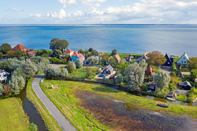 High angle view of houses by sea against sky