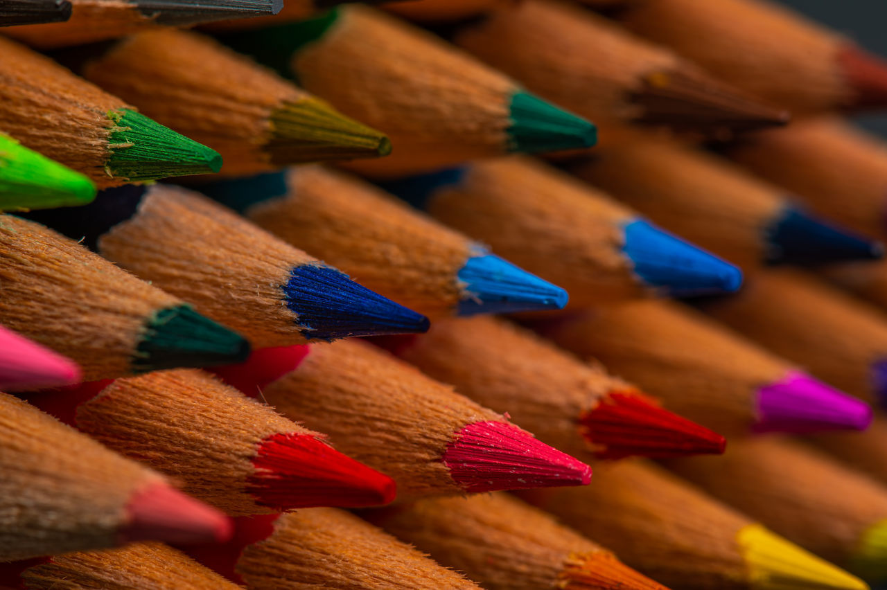 CLOSE-UP OF MULTI COLORED PENCILS ON WOOD
