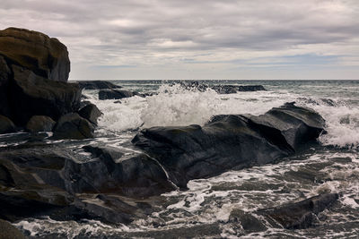 Scenic view of rocks in sea against sky