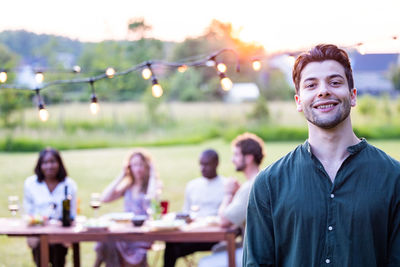 Portrait of smiling friends sitting at restaurant