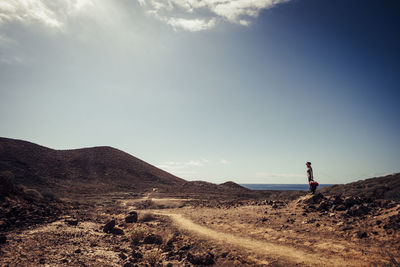 Woman standing on land against sky