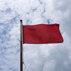 Low angle view of flag against cloudy sky