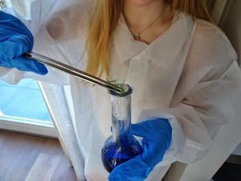 Midsection of girl mixing plant in chemical