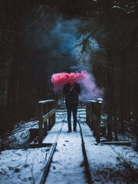 Man standing on snow covered tree