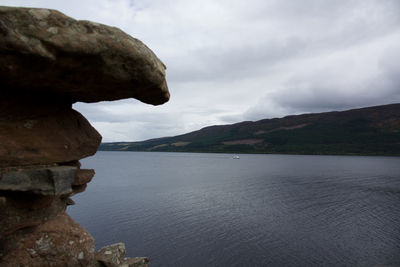 Rock formations by sea against sky