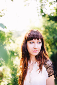 Portrait of beautiful young woman standing against wall