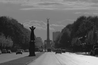 Statue in city against sky