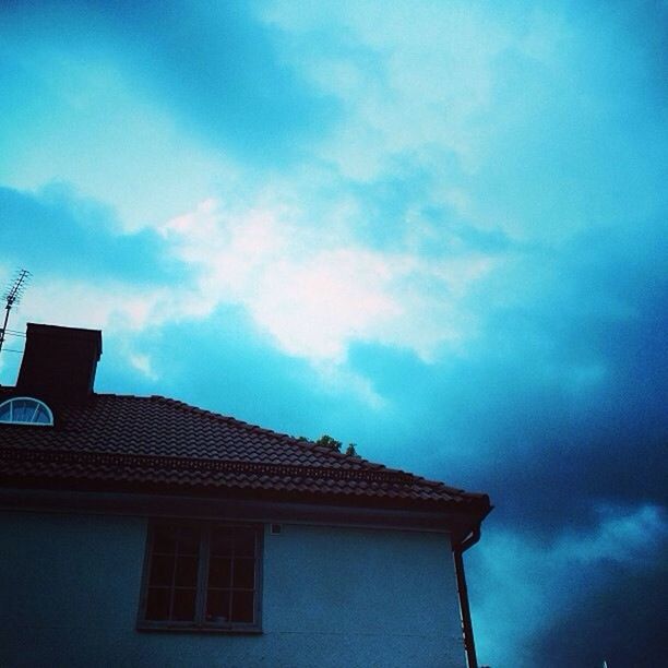 low angle view, building exterior, architecture, built structure, sky, cloud - sky, high section, cloud, window, building, house, cloudy, residential structure, residential building, blue, outdoors, no people, street light, day, roof